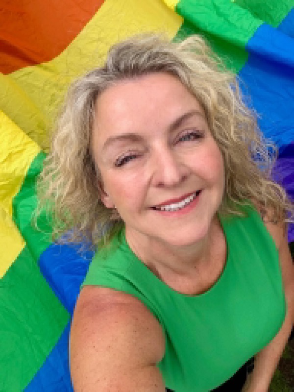 Emma Järund framför en regnbågsflagga under Pride