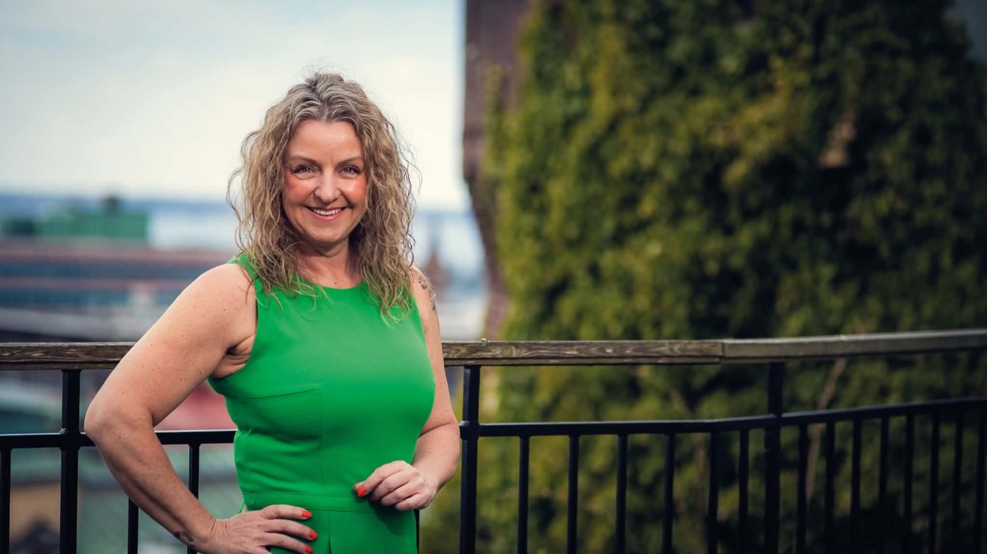 Emma Järund, riksdagskandidat för Centerpartiet, på en balkong med Helsingborgs takåsar i bakgrunden